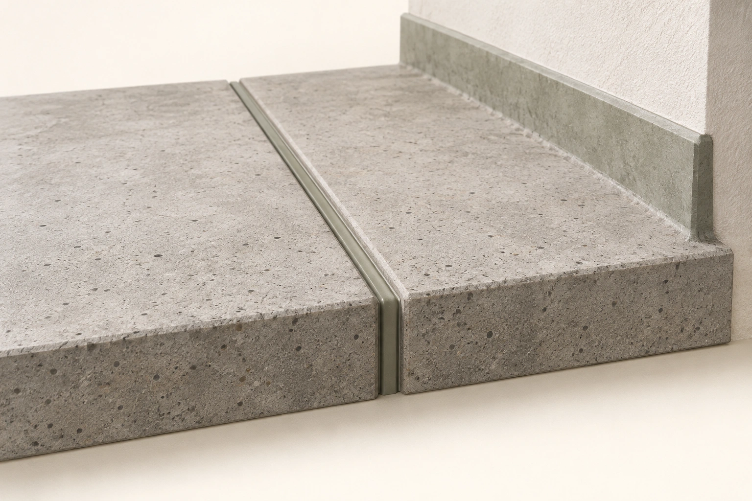 Two concrete surfaces with narrow sealed joint and adjacent upstand visible. Conceptual relationship only; no actual installed detail or performance proved.